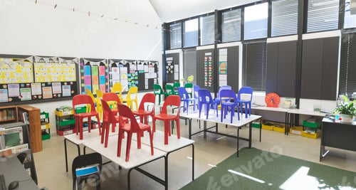Preview: Front view of color chairs arranged on table in empty classroom at school