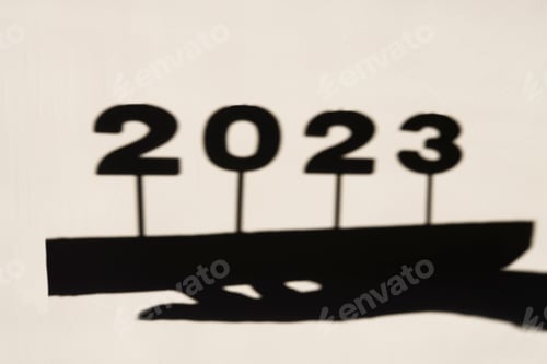 Fundo abstrato com sombra e reflexo dos números 2023 na parede.