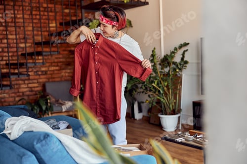 Preview: Young Adult Tries on Red Button Down Shirt