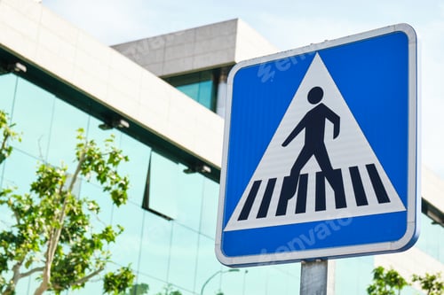 Preview: blue square crosswalk traffic sign with glass building in the background