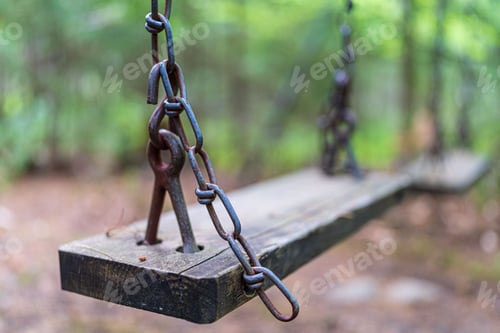 Preview: Closeup of a chain swing with a wooden chair.