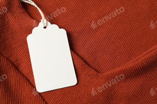 Preview: Cardboard tag on orange garment, top view