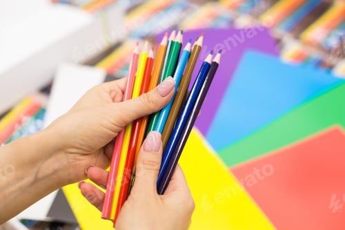 Preview: Back to school. Woman in a stationery store picks out colored pencils.