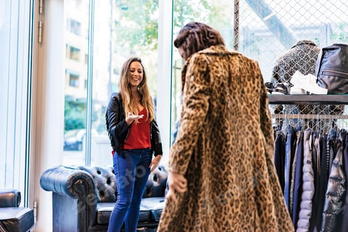 Preview: two mixed race female friends buying clothes in a store and having fun