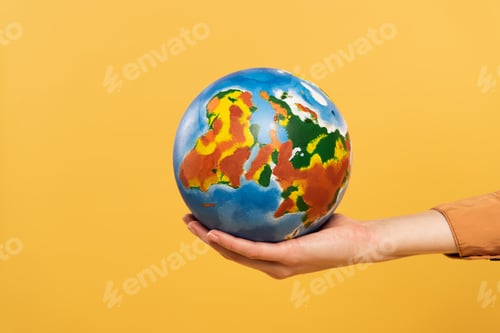 Preview: Cropped view of globe in woman hand isolated on yellow