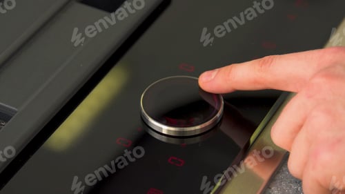 Preview: Finger pressing on electronic panel of stove. Household utensils. Close-up of electric stove control