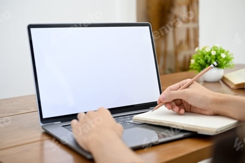Preview: Close-up, A man working on his project, using laptop computer and taking notes on his book.