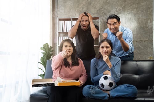 Preview: Friends watch sports on TV, cheer and celebrate. Happy diverse asian friend supporters fans sit on