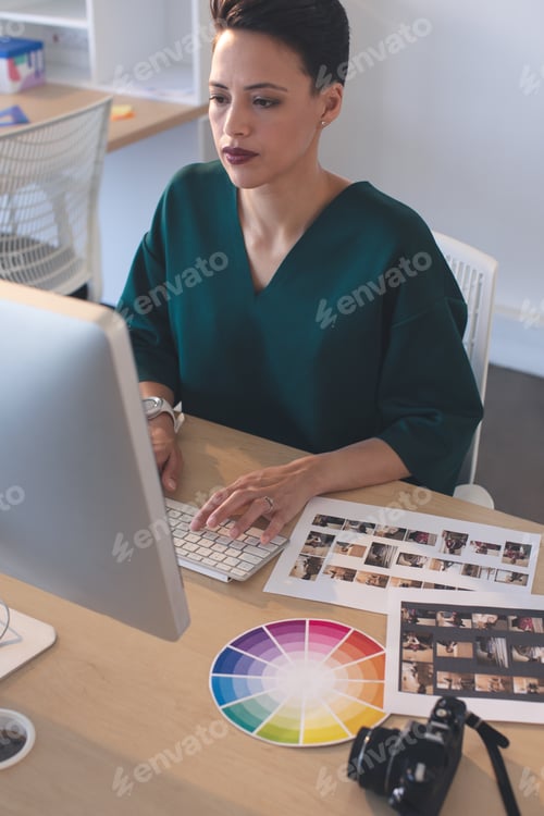 Preview: Female graphic designer working on computer at desk in the office