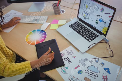 Preview: Female editor using digitizer on desk in office