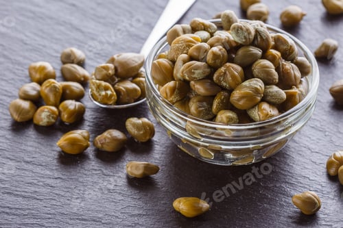 Preview: pickled capers on a dark stone background
