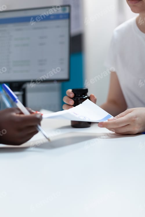 Preview: Closeup of african american therapist giving antibiotic prescription to patient