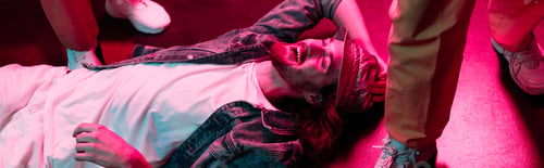 Preview: panoramic shot of smiling man lying on floor in nightclub