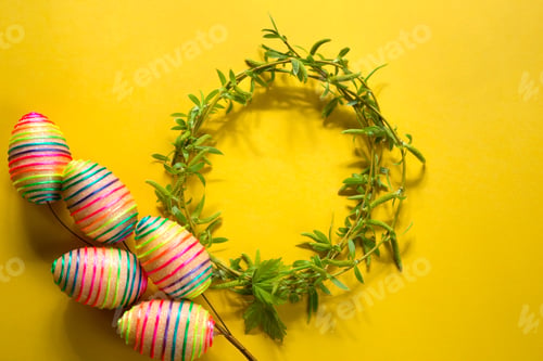 Preview: A wreath of young spring leaves on branches with colorful Easter eggs.