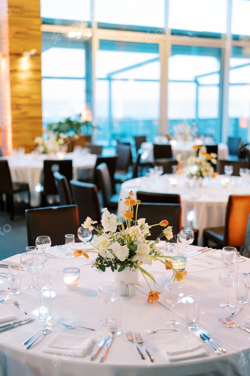 Preview: Colorful bouquet of flowers stands on a round table with lit candles in candlesticks