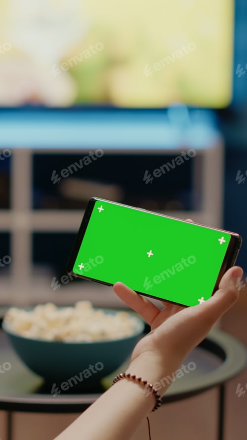 Preview: Person holding modern phone with horizontal green screen