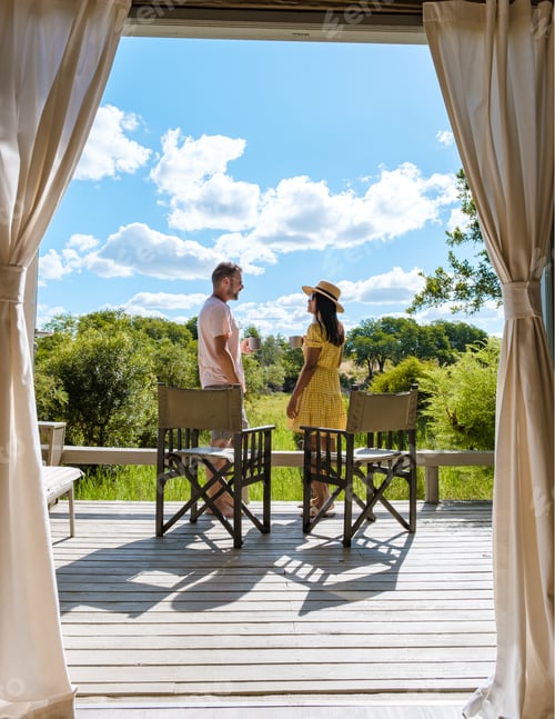 Preview: couple on safari in South Africa, Asian women and European men at a tented camp lodge during safari