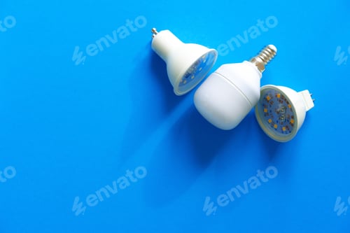 Preview: Light bulbs on blue paper background close up