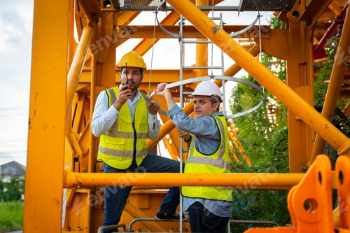 Preview: Two men in yellow vests are working on a construction site