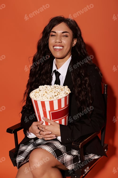 Preview: Student enjoys a playful moment with popcorn against a vibrant backdrop full of energy