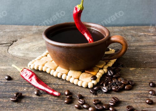 Preview: Spicy black coffee in small cup with beans and chilli isolated on white