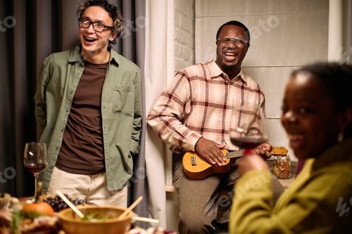 Preview: Diverse Young Adults Laughing and Socializing during Thanksgiving Dinner