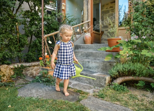Preview: Little girl in a small garden with green watering pot