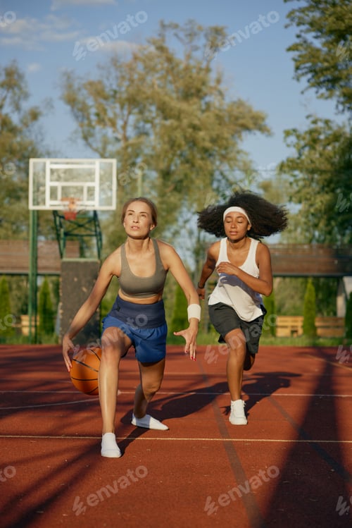 Preview: Female basketball players running with ball ready to pass into basket
