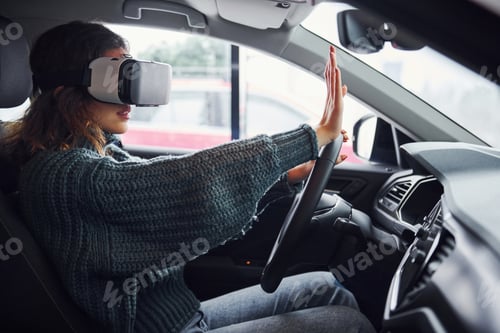 Preview: Side view of woman in virtual reality glasses that sitting inside of modern car