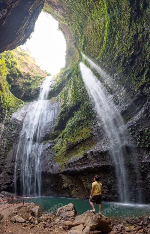 Preview: Majestic waterfall flowing on rocky cliff in tropical rainforest