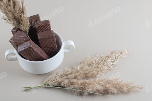 Preview: Bowl of chocolate wafers and feather grass stalks on marble background