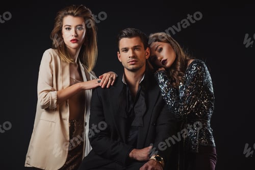 Preview: attractive and stylish women hugging handsome man isolated on black
