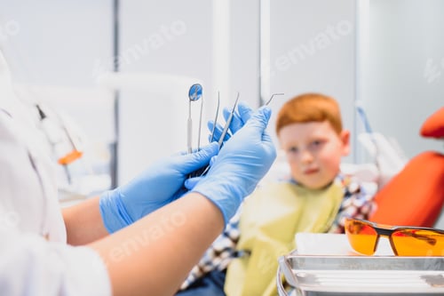 Preview: Portrait of a dentist holding dental instruments in his hands in the clinic close-up