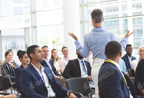 Preview: Mature caucasian businesswoman asking question to diverse business people during seminar