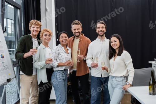 Preview: Multicultural business people holding glasses of champagne in office