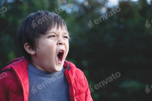 Preview: Tired child yawning and get a cold during weather.Child having allergy while playing in the park