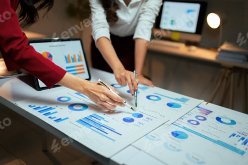 Preview: Businesswomen analyzing financial data with charts and graphs