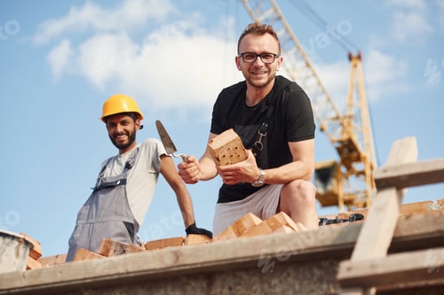 Preview: Man in glasses is standing with Indian guy on the construction site