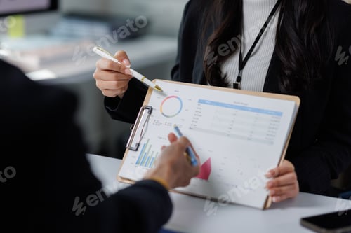 Preview: Business people analyzing financial data charts in a meeting