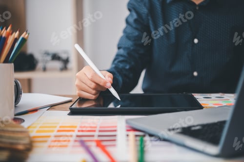 Preview: Graphic designer architects who work with laptops and color comparison tables for design work.