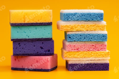 Preview: Stacked household cleaning sponges on yellow background