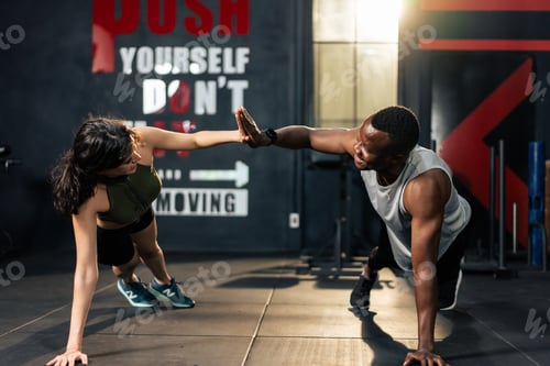 Preview: American African sportsman and Latino sportswoman working out together.