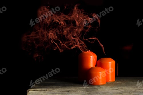 Preview: Three extinguished candles orange color on the table. Halloween holiday concept.