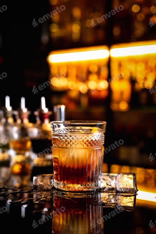 Preview: A cocktail in an old fashioned glass on a bar counter with a reflection