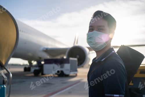 Preview: Asian man wearing face mask walks to stair entering airplane.