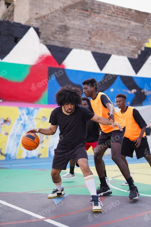Preview: Multiracial friends having fun playing basket ball in the city