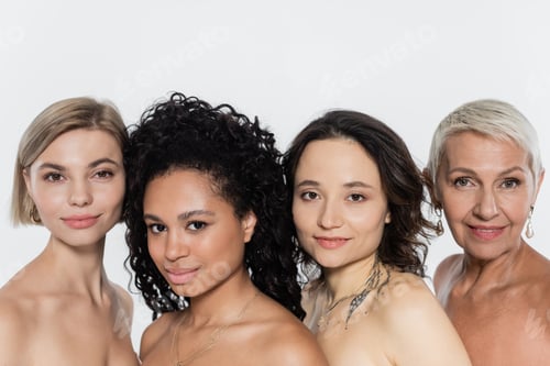 Preview: Positive interracial women with naked shoulders looking at camera isolated on grey