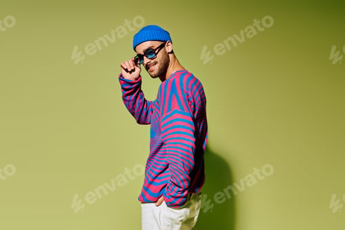 Preview: Stylish young man showcasing vibrant fashion sense in trendy studio setting