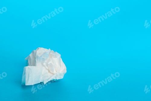Preview: Crumpled paper on blue background with focus on texture and color contrast