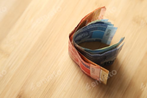 Preview: High angle shot of a some cash money on a wooden surface